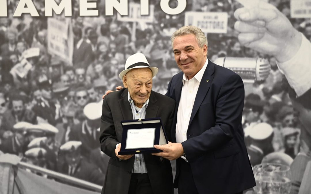 Il Segretario Generale della Cisl Luigi Sbarra consegna  una targa ricordo al “maestro” Carlo Riccardi